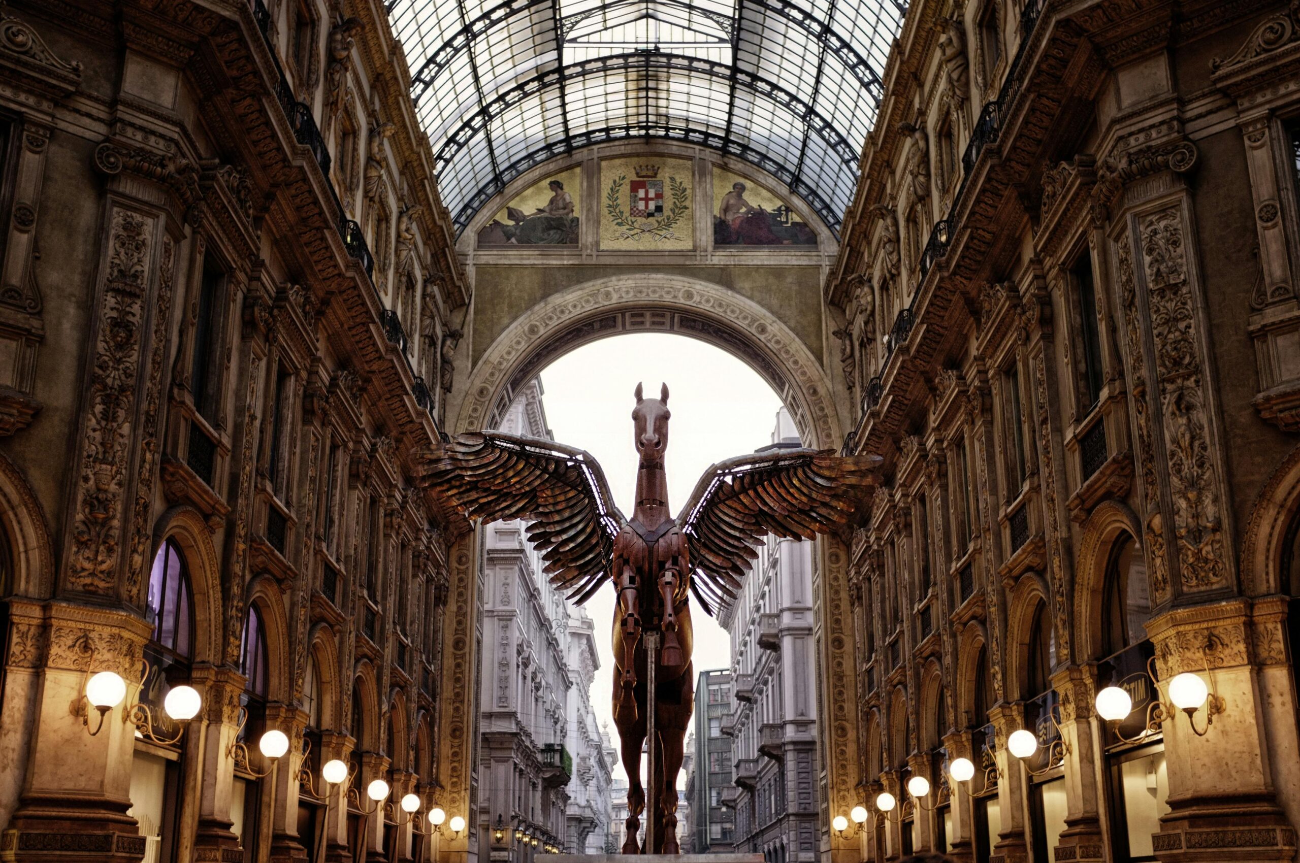 Stunning view of the Galleria Vittorio Emanuele II showcasing a Pegasus statue beneath the iconic skylight.