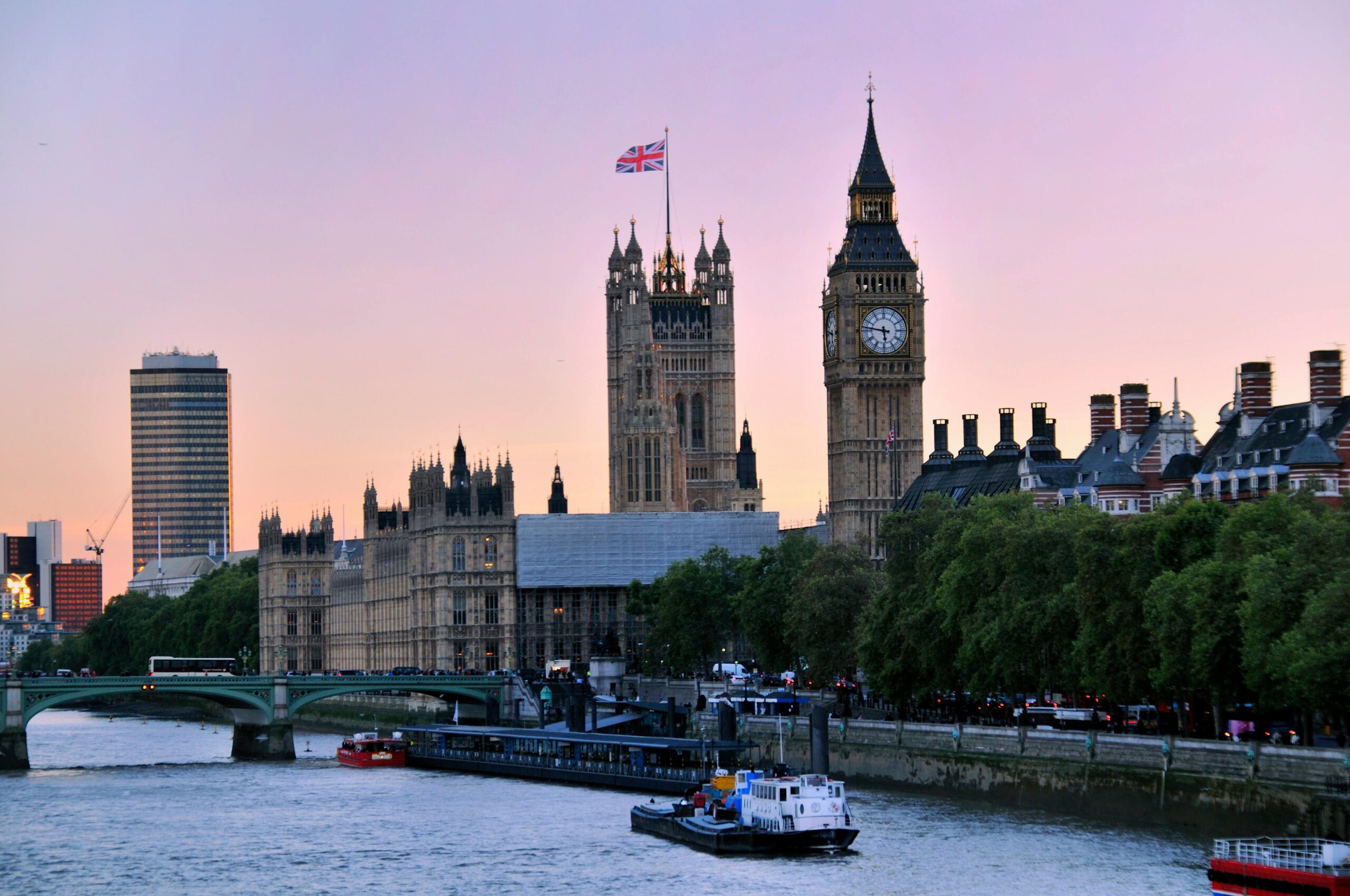 Iconic view of Big Ben and the Houses of Parliament by the River Thames during sunset in London.